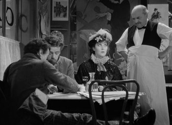 Movie still from “The Life of Emile Zola” (1937), directed by William Dieterle – A group of people sitting around a table; Medium shot, High angle