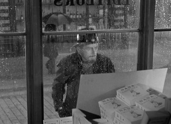 Movie still from “The Life of Emile Zola” (1937), directed by William Dieterle – A black and white photo of a man looking out of a store window; Medium shot, Over the shoulder angle