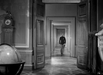 Movie still from “The Life of Emile Zola” (1937), directed by William Dieterle – A man walking down a hall way in a building; Wide shot, High angle