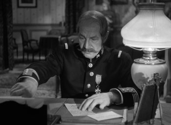 Movie still from “The Life of Emile Zola” (1937), directed by William Dieterle – An old man in a uniform sitting at a table; Medium shot, High angle