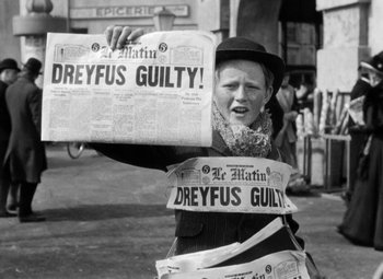 Movie still from “The Life of Emile Zola” (1937), directed by William Dieterle – An old woman holding newspapers in front of her face; Medium shot, Over the shoulder angle