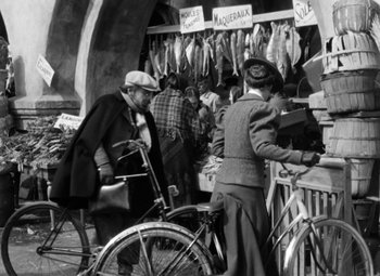 Movie still from “The Life of Emile Zola” (1937), directed by William Dieterle – An old black and white photo of a man on a bicycle; Wide shot, High angle