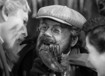 Movie still from “The Life of Emile Zola” (1937), directed by William Dieterle – An old man wearing a hat and glasses holding a lobster; Close Up shot, Over the shoulder angle