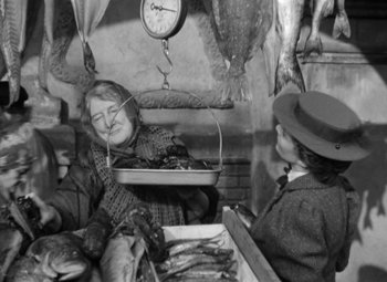 Movie still from “The Life of Emile Zola” (1937), directed by William Dieterle – Two women sitting at a table in a market; Medium shot, Over the shoulder angle