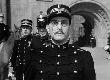 Movie still from “The Life of Emile Zola” (1937), directed by William Dieterle – A man in a military uniform with a mustache and glasses; Close Up shot, Low angle
