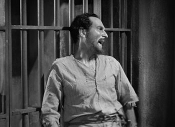 Movie still from “The Life of Emile Zola” (1937), directed by William Dieterle – A black and white photo of a man with a beard; Medium shot, High angle