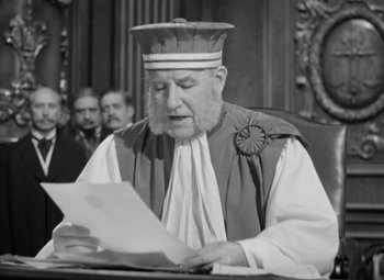 Movie still from “The Life of Emile Zola” (1937), directed by William Dieterle – An old man wearing a priest's outfit reading a paper; Close Up shot, Low angle