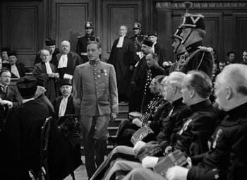 Movie still from “The Life of Emile Zola” (1937), directed by William Dieterle – A group of men in suits and hats in a courtroom; Medium shot, Over the shoulder angle