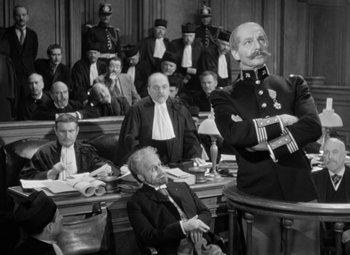 Movie still from “The Life of Emile Zola” (1937), directed by William Dieterle – An old photo of a man in a court room; Medium shot, Low angle