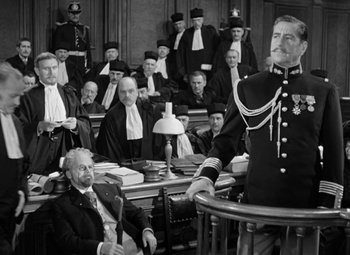 Movie still from “The Life of Emile Zola” (1937), directed by William Dieterle – A black and white photo of a man in a court room; Medium shot, High angle