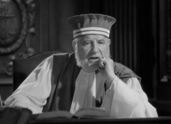 Movie still from “The Life of Emile Zola” (1937), directed by William Dieterle – An old man wearing a hat sitting at a table; Close Up shot, Low angle
