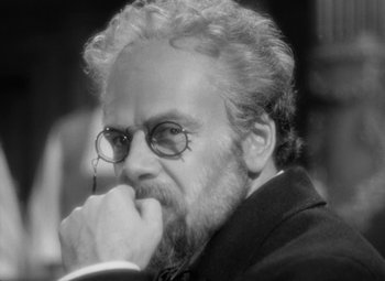 Movie still from “The Life of Emile Zola” (1937), directed by William Dieterle – An older man with a beard wearing glasses and a suit; Close Up shot, Over the shoulder angle
