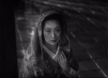 A woman in a kimono with her hand on her chin