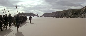 Movie still from “The Lion in Winter” (1968), directed by Anthony Harvey – A group of people walking on the beach; Extreme Wide shot, High angle