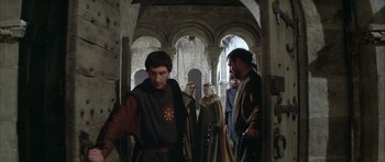 Movie still from “The Lion in Winter” (1968), directed by Anthony Harvey – A group of men in medieval garb standing in an archway; Medium shot, Over the shoulder angle