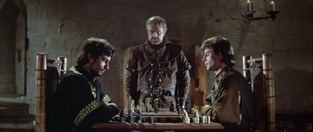 Movie still from “The Lion in Winter” (1968), directed by Anthony Harvey – A group of men sitting at a table playing chess; Medium shot, Over the shoulder angle