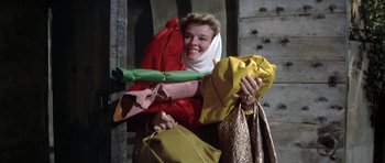 Movie still from “The Lion in Winter” (1968), directed by Anthony Harvey – A woman in a red dress holding a yellow bag; Medium shot, Low angle