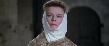 Movie still from “The Lion in Winter” (1968), directed by Anthony Harvey – An older woman wearing a head covering and a gold dress; Close Up shot, Low angle