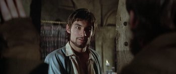 Movie still from “The Lion in Winter” (1968), directed by Anthony Harvey – A man with long hair and a beard is standing in a room; Close Up shot, Over the shoulder angle