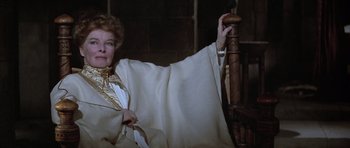 Movie still from “The Lion in Winter” (1968), directed by Anthony Harvey – An older woman sitting on a chair in a dark room; Medium shot, Over the shoulder angle