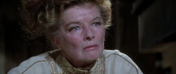 Movie still from “The Lion in Winter” (1968), directed by Anthony Harvey – An older woman wearing a white shirt and a gold necklace; Close Up shot, Over the shoulder angle