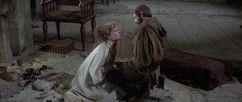 Movie still from “The Lion in Winter” (1968), directed by Anthony Harvey – A woman kneeling on the ground next to a man; Medium shot, High angle