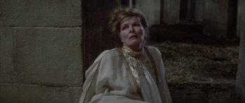 Movie still from “The Lion in Winter” (1968), directed by Anthony Harvey – An older woman in a white dress looking up at the sky; Close Up shot, High angle