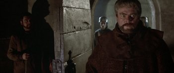 Movie still from “The Lion in Winter” (1968), directed by Anthony Harvey – A man in a helmet standing next to another man; Medium shot, Over the shoulder angle