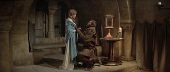 Movie still from “The Lion in Winter” (1968), directed by Anthony Harvey – A man kneeling down on a woman's dress; Wide shot, High angle