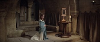 Movie still from “The Lion in Winter” (1968), directed by Anthony Harvey – A young girl in a dress standing in front of an alter; Wide shot, High angle