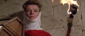 Movie still from “The Lion in Winter” (1968), directed by Anthony Harvey – A woman wearing a head scarf and a red shirt; Close Up shot, Low angle