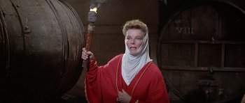 Movie still from “The Lion in Winter” (1968), directed by Anthony Harvey – A woman in a red robe holding a torch in front of a barrel; Medium shot, Low angle