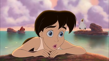 Movie still from “The Little Mermaid II: Return to the Sea” (2000), directed by Bill Speers – A young boy laying on the ground with a bird in the background; Medium shot, Low angle