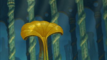 Movie still from “The Little Mermaid II: Return to the Sea” (2000), directed by Bill Speers – A yellow flower in front of a wall of pillars; Extreme Wide shot, Low angle