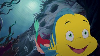 Movie still from “The Little Mermaid: Ariel's Beginning” (2008), directed by Peggy Holmes – A cartoon of a yellow fish holding a red fish; Medium shot, Overhead angle