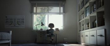 Movie still from “The Little Prince” (2015), directed by Mark Osborne – A person sitting at a desk in front of a window; Wide shot, Low angle