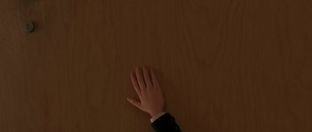 Movie still from “The Little Prince” (2015), directed by Mark Osborne – A person's hand reaching for something on a wooden surface; Extreme Close Up shot, Overhead angle