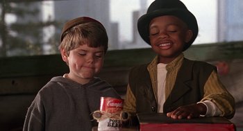Movie still from “The Little Rascals” (1994), directed by Penelope Spheeris – Two young boys are looking at a can of cereal; Close Up shot, High angle