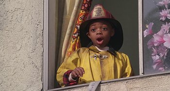 Movie still from “The Little Rascals” (1994), directed by Penelope Spheeris – A boy in a fireman's outfit looking out of a window; Close Up shot, Low angle