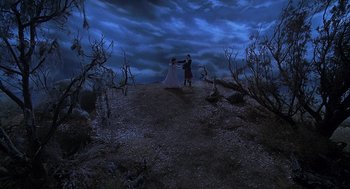 Movie still from “The Little Rascals” (1994), directed by Penelope Spheeris – A man and a woman are dancing on a hill at night; Extreme Wide shot, High angle