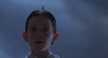Movie still from “The Little Rascals” (1994), directed by Penelope Spheeris – A little boy with a hairpiece on his head; Close Up shot, Low angle