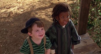 Movie still from “The Little Rascals” (1994), directed by Penelope Spheeris – Two young children standing next to each other on a path; Close Up shot, High angle