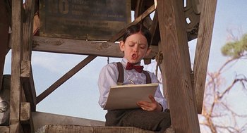 Movie still from “The Little Rascals” (1994), directed by Penelope Spheeris – A young boy sitting on top of a wooden structure; Close Up shot, Low angle