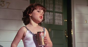 Movie still from “The Little Rascals” (1994), directed by Penelope Spheeris – A little girl in a white dress holding a cup; Close Up shot, Low angle
