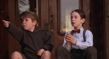 Movie still from “The Little Rascals” (1994), directed by Penelope Spheeris – Two young boys sitting next to each other on a train; Medium shot, Low angle