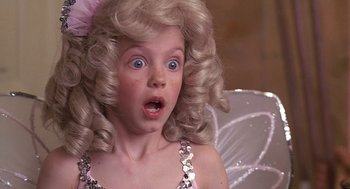 Movie still from “The Little Rascals” (1994), directed by Penelope Spheeris – A young girl with blonde curly hair wearing a silver dress and a pink bow; Close Up shot, High angle