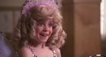 Movie still from “The Little Rascals” (1994), directed by Penelope Spheeris – A little girl in a pink and silver dress; Close Up shot, High angle