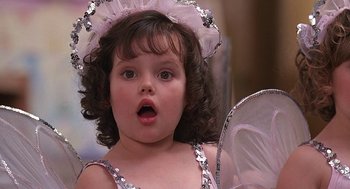Movie still from “The Little Rascals” (1994), directed by Penelope Spheeris – A little girl in a fairy costume looking surprised; Close Up shot, High angle