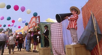 Movie still from “The Little Rascals” (1994), directed by Penelope Spheeris – A boy on stage with a big horn horn; Wide shot, Low angle
