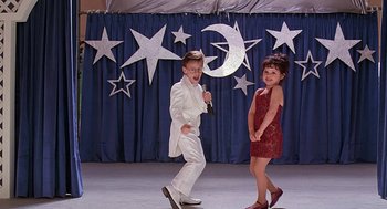 Movie still from “The Little Rascals” (1994), directed by Penelope Spheeris – A boy and a little girl dancing on a stage; Wide shot, Low angle